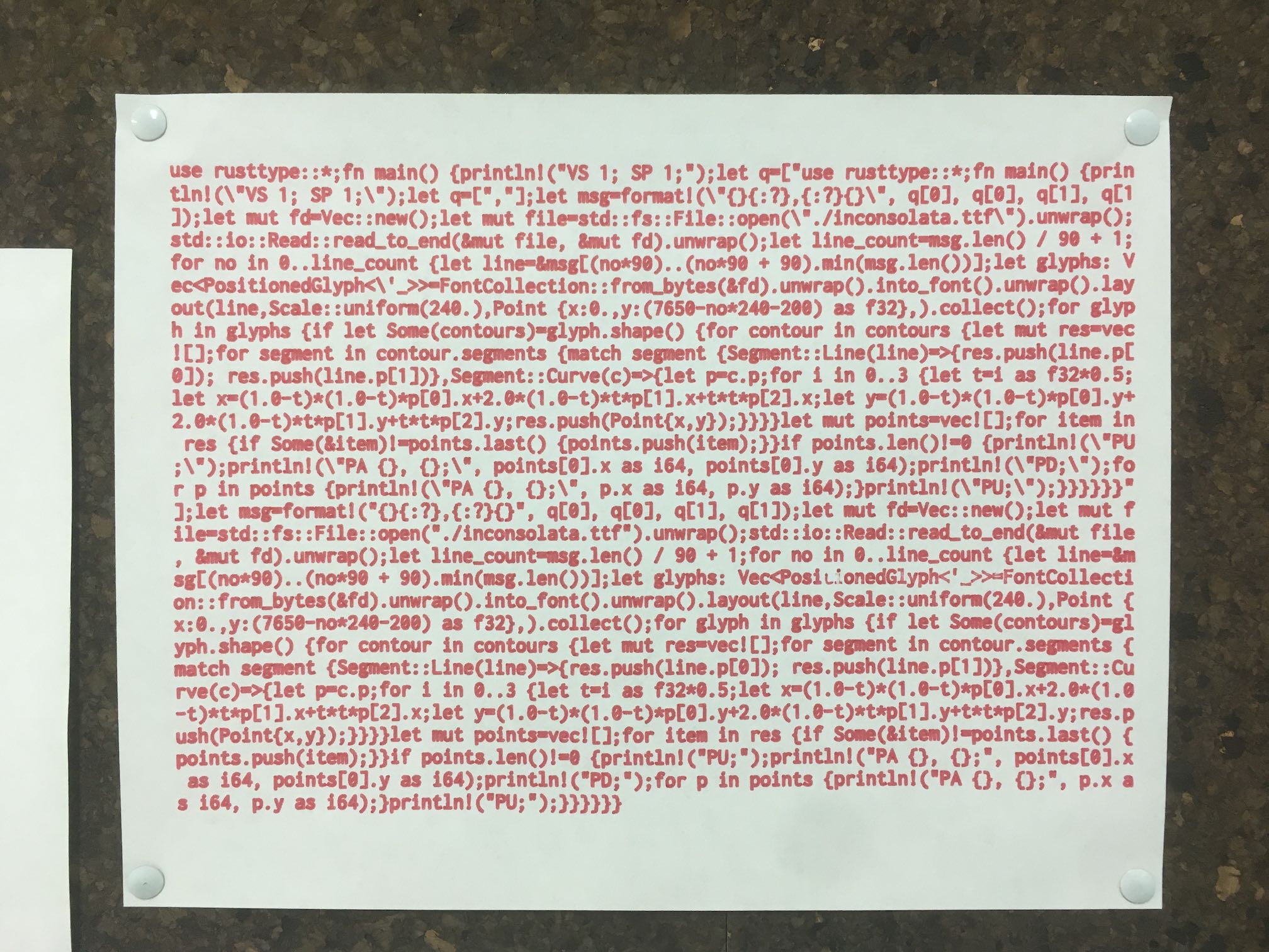 The source code of the quine, printed by a plotter on an 8.5x11 sheet of paper and hung on a wall